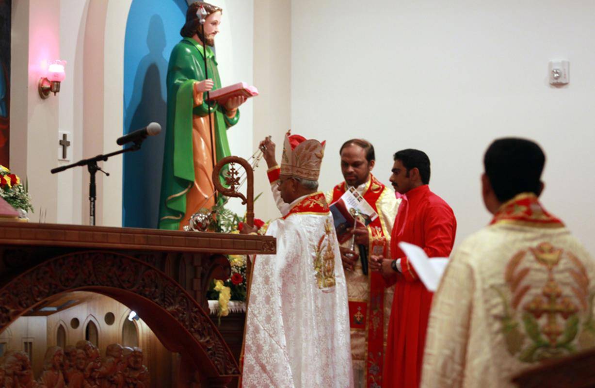 Bishop Jacob Angadiath censes one of four small crosses marking the walls of St. Mary's Syro-Malabar Church, during the dedication rite for the new church.