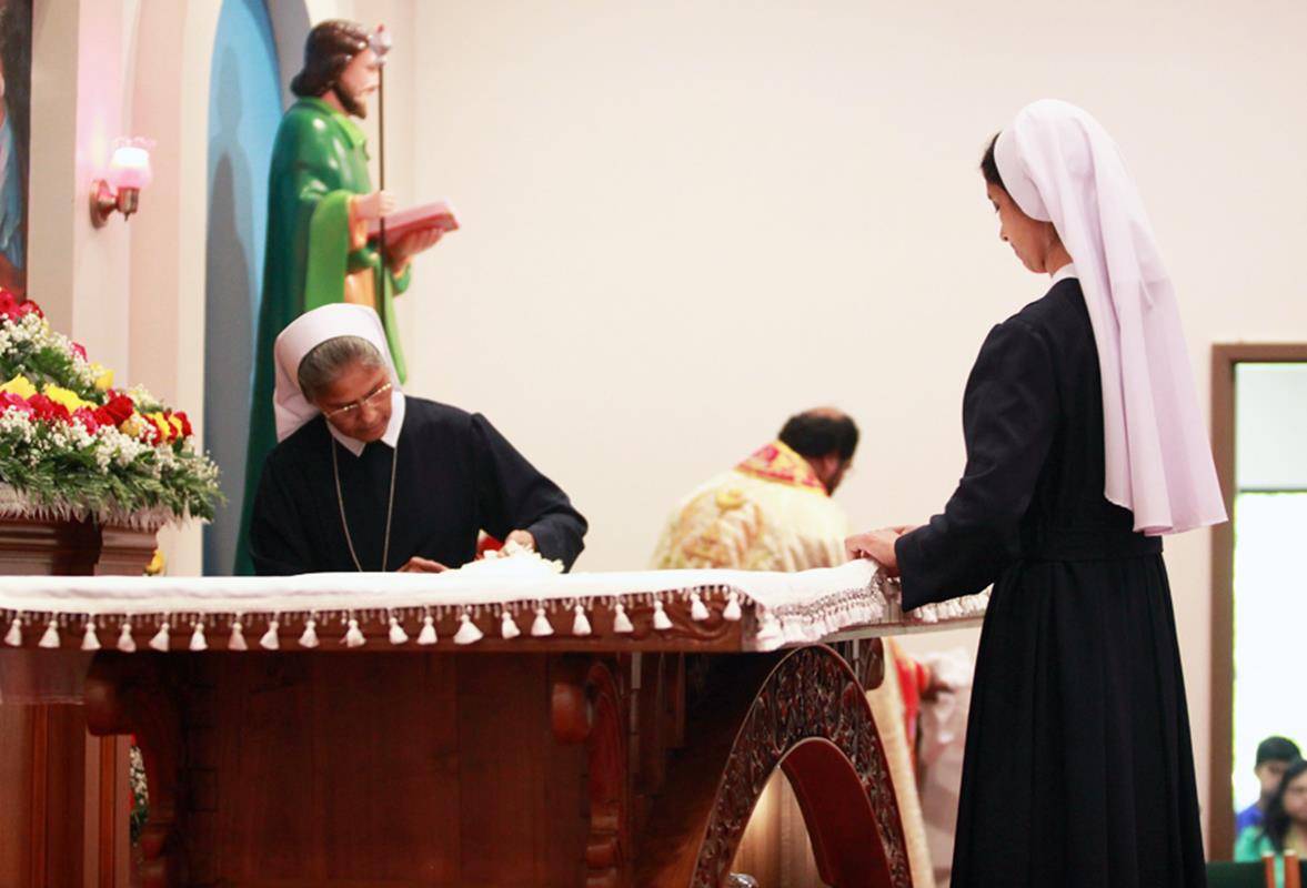 St. Vincent de Paul sisters dress the high altar with sacred linens after it was consecrated by Bishop Jacob Angadiath.