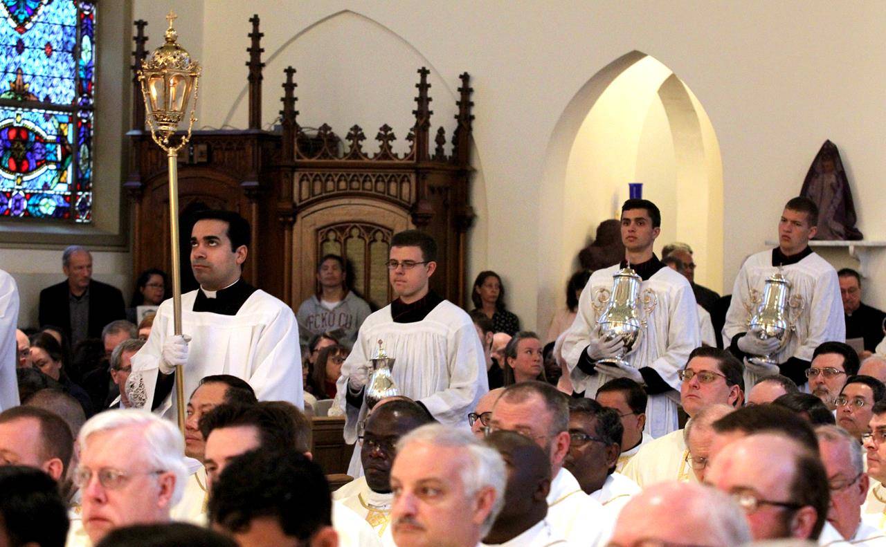 The oils to be blessed at the Chrism Mass are brought forward to the altar.