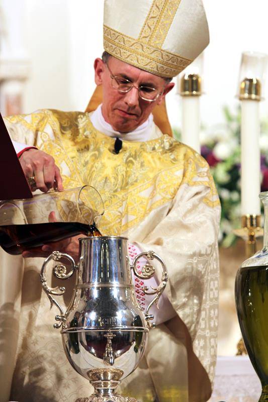 Bishop Jugis prepares the oils that he will bless. The holy oils are used in the sacraments at all of the churches in the diocese throughout the year. Each year during Holy Week, new oils are blessed and distributed to every parish.