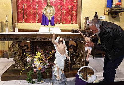 Faithful place candles and statues in front of the altar of repose to be blessed at Immaculate Conception Church in Forest City. (Photo by Giuliana Polinari Riley, correspondent)