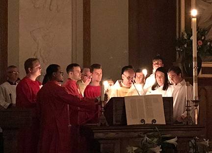 Chanting of the Exsultet at the Easter Vigil at St. Peter Church in Charlotte. Twelve people entered the Church during the liturgy, celebrated by Jesuit Father James Shea, pastor (Photo provided by Joan Guthrie)