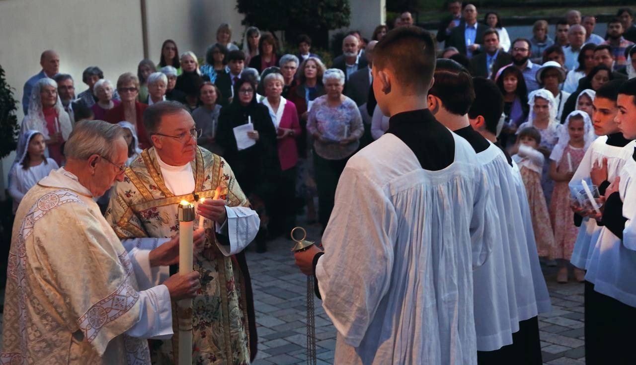 Father Roger Arnsparger and members of St. John the Baptist Church in Tryon during the lighting of the Paschal candle to start the Easter Vigil Mass. (Photo by Giuliana Polinari Riley, correspondent)