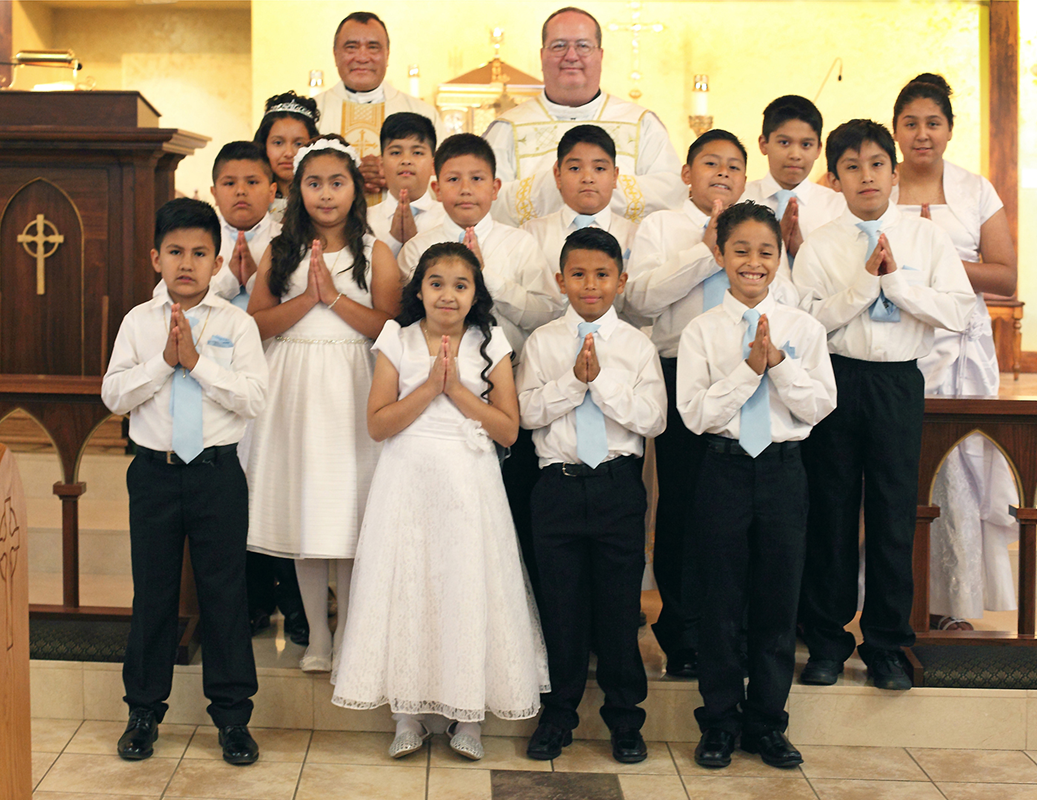 FOREST CITY — Fourteen children received the sacrament of first Holy Communion at Immaculate Conception Church May 27, during a Spanish-language Mass offered by Father José Antonio Juya, with Father Herbert Burke, pastor, as concelebrant. (Giuliana Polina