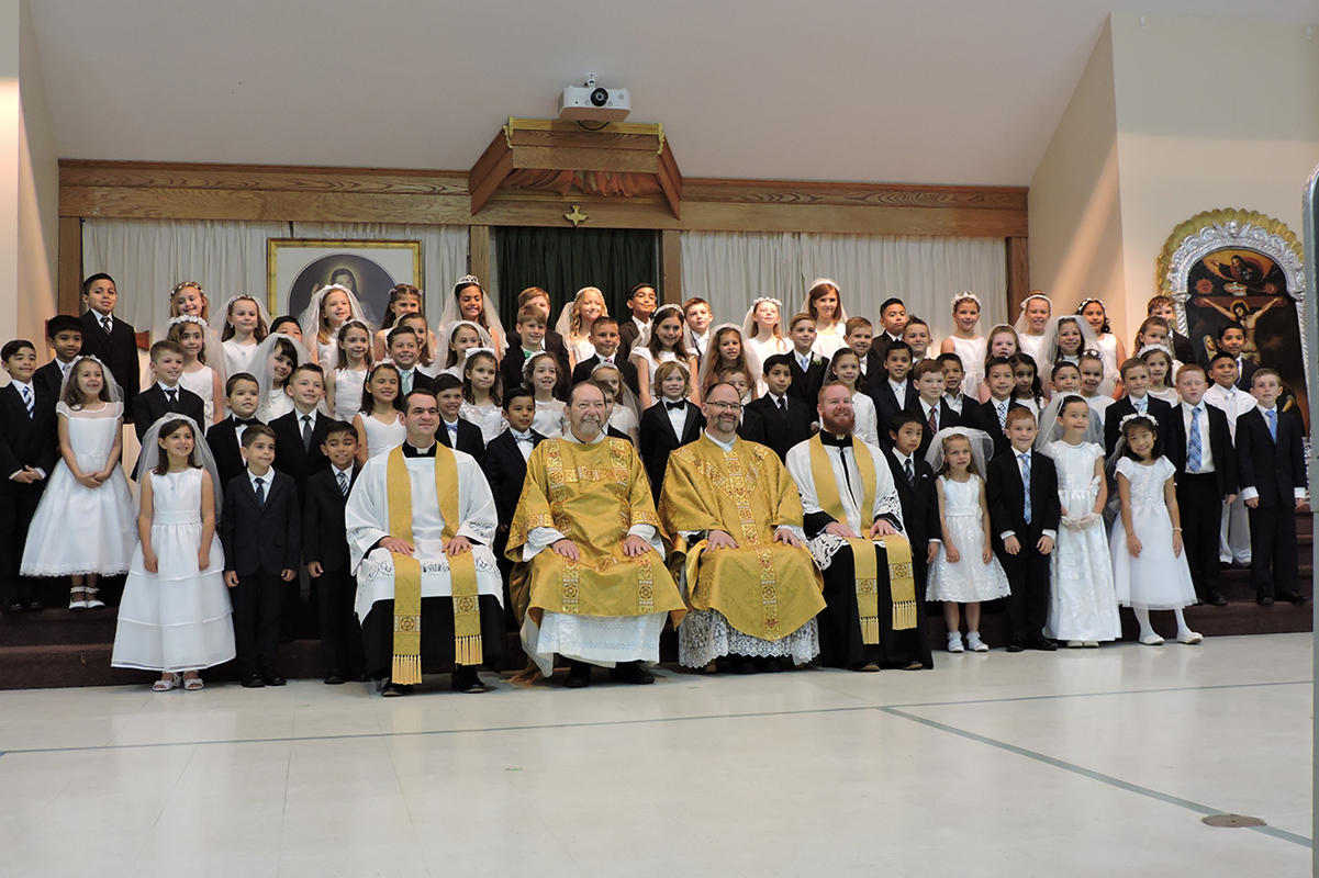 HUNTERSVILLE — Children at St. Mark Church received their first Holy Communion during two Masses April 28, celebrated by Father John Putnam, pastor, and Father Brian Becker, parochial vicar. After Mass, all of the children were enrolled in the Brown Scapu