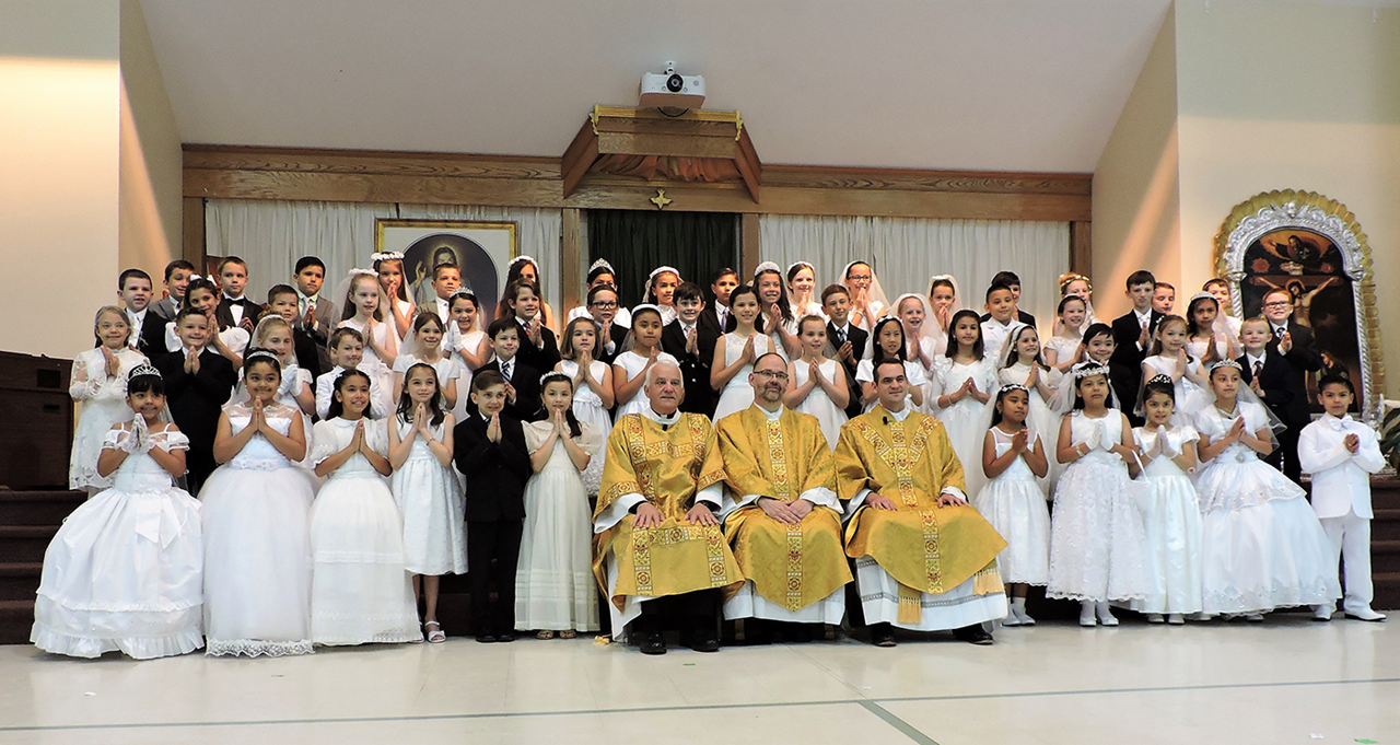 HUNTERSVILLE — Children at St. Mark Church received their first Holy Communion during two Masses April 28, celebrated by Father John Putnam, pastor, and Father Brian Becker, parochial vicar. After Mass, all of the children were enrolled in the Brown Scapu