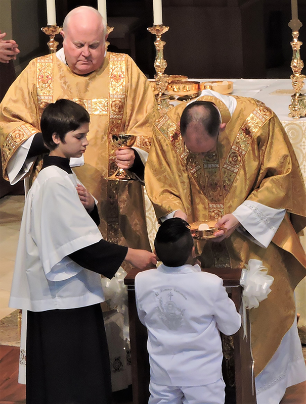 HUNTERSVILLE — Children at St. Mark Church received their first Holy Communion during two Masses April 28, celebrated by Father John Putnam, pastor, and Father Brian Becker, parochial vicar. After Mass, all of the children were enrolled in the Brown Scapu