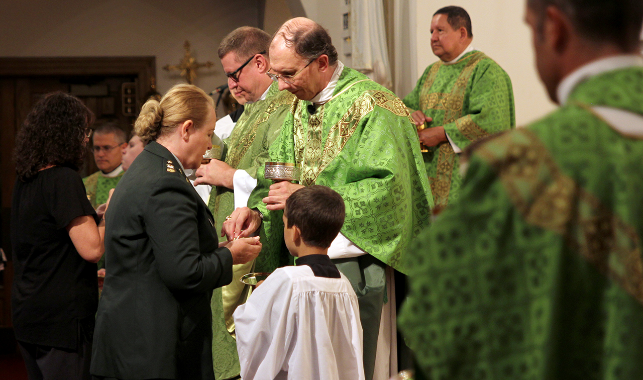 Ret. Army Major Marjorie Hooper of Charlotte receives Communion at the Mass.