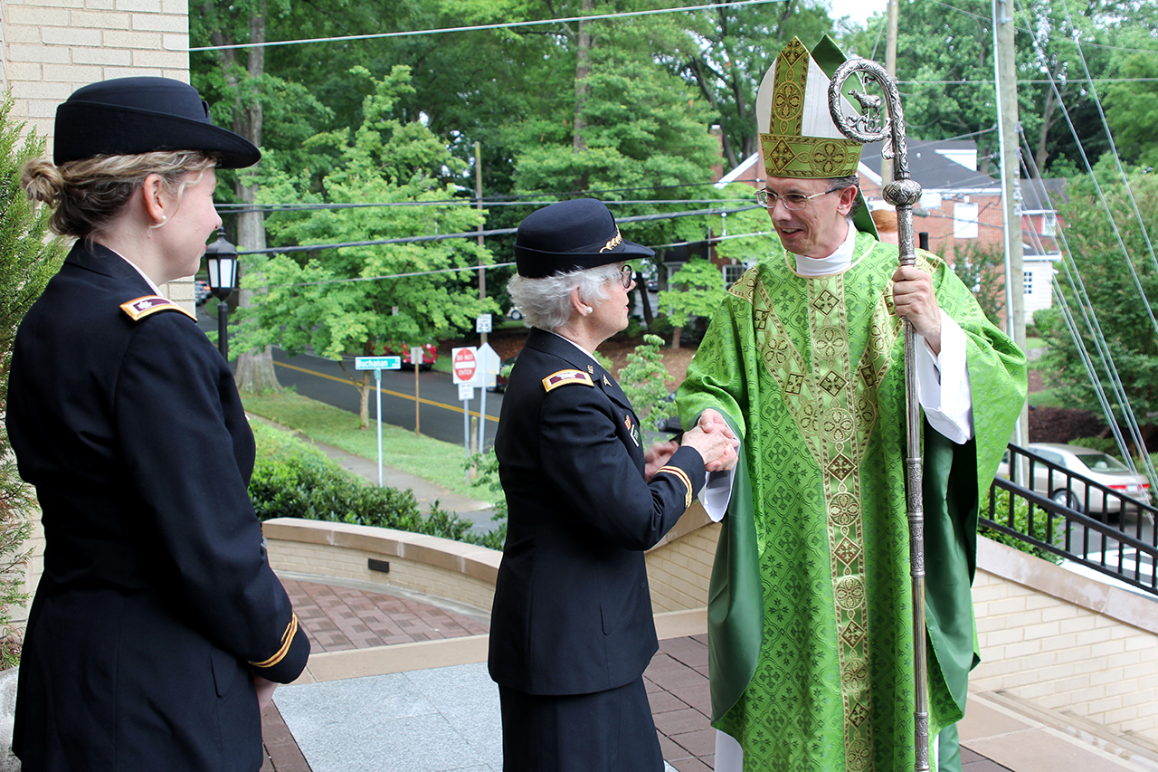 Ret. Army Col. Rebecca Tomsyck and Army Reserve Lt. Col. Nicole French, both of Charlotte, greet Bishop Jugis after the Mass.