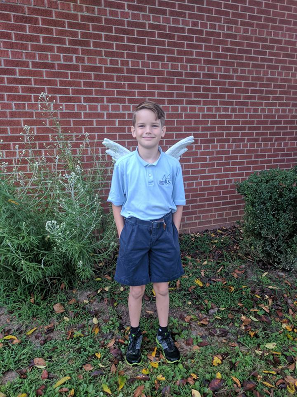 William's first day of fifth grade posing in front of the angel statue in front of Asheville Catholic School.
