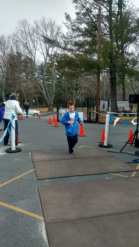 William Edward crossing the finish line of the Shamrock Run March 2017 his pockets were full of pine cones he had collected along the way.