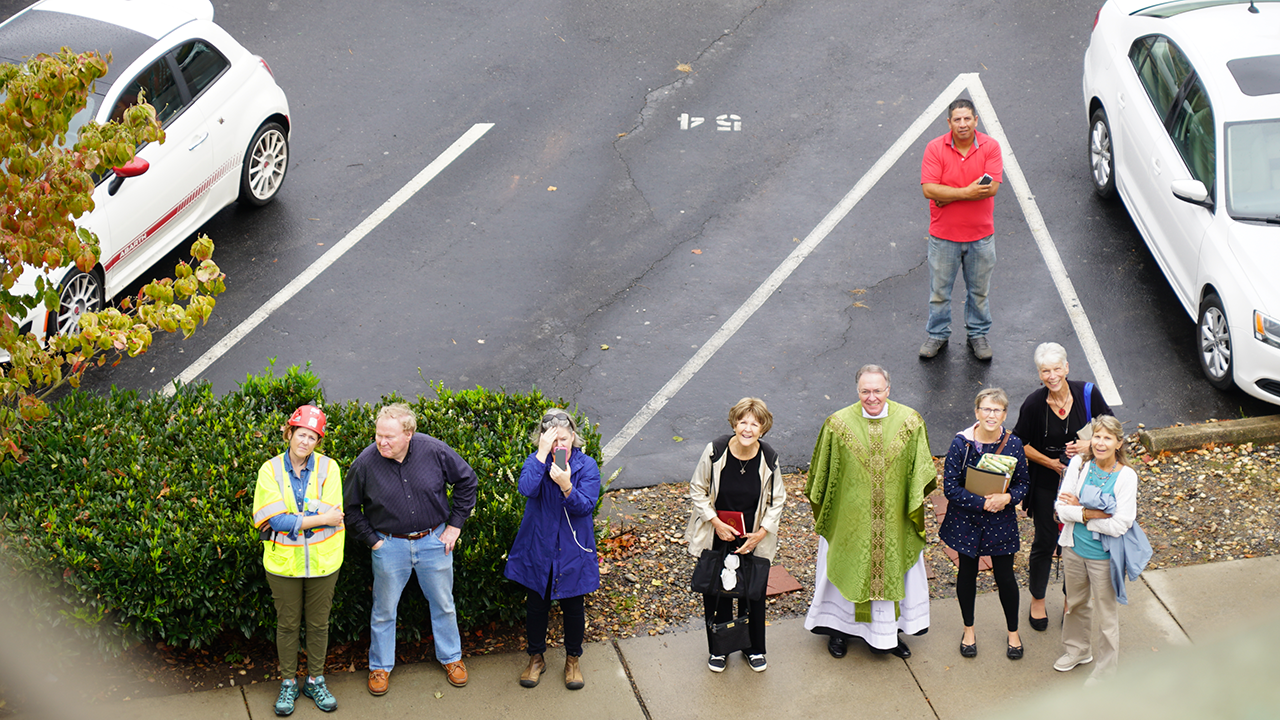 Father Roger Arnsparger, pastor, and parishioners watch as the basilica is surveyed Oct. 10.
