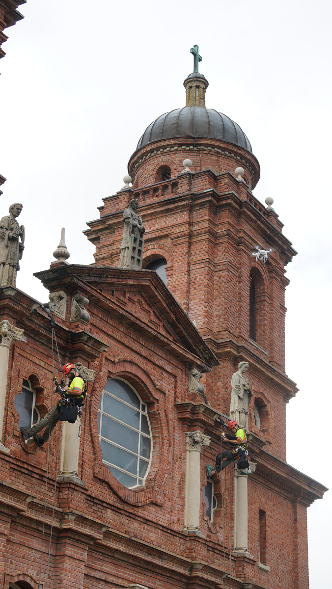 A drone flies above Vertical Access rappelers Oct. 10 as St. Lawrence Basilica gets a thorough evaluation inside and out, the first step in planning a restoration of the century-old church in downtown Asheville.