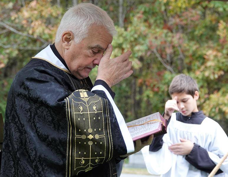 Father Becker celebrated the Mass with Deacon Louis Pais assisting. Father Becker led a procession blessing the graves with holy water while Director of Sacred Music Michael Garnett chanted the Litany of the Saints. (Photos by Amy Burger)