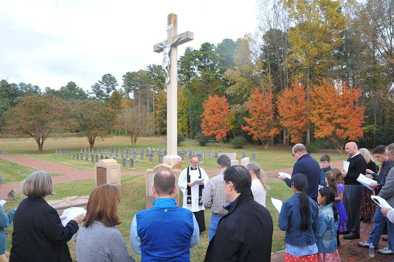 BELMONT — Approximately 60 people joined Father Timothy Reid, pastor of St. Ann Church in Charlotte, as he offered prayers for the poor souls in purgatory Nov. 4 at Belmont Abbey’s cemetery. (Markus Kuncoro and Mike FitzGerald | Catholic News Herald)
