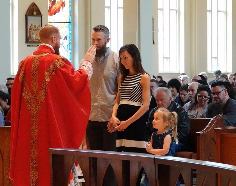 Father Carter imparts a blessing after receiving the offertory gifts during the Palm Sunday liturgy at St. Mark Church.