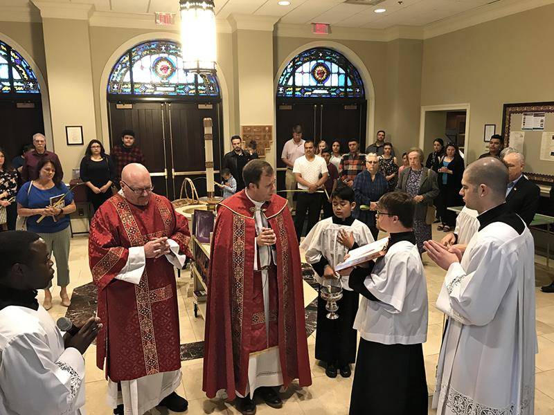 Father John Eckert, pastor, prays at the start of the Palm Sunday Mass April 14 at Sacred Heart Church in Salisbury. (Photo by Bill Washington, Catholic News Herald)