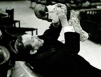 Father Francis Smith with a baby in 1979.