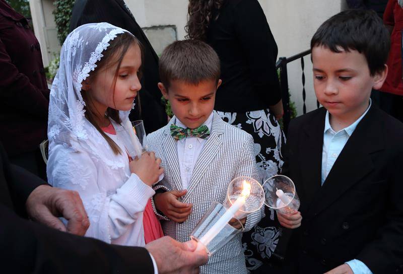 Children at St. John the Baptist Church in Tryon light their candles at the start of the Easter Vigil April 20. (Photo by Guiliana RIley)