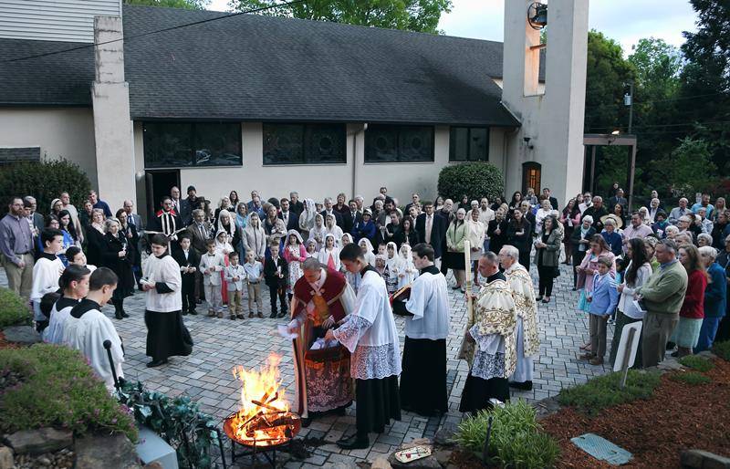 Father Jason Christian, pastor, burn Lent promises at St. John the Baptist Church in Tryon. (Photo by Guiliana RIley)