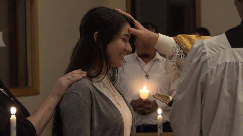 Dakota Ostronic receives the sacrament of confirmation at St. Mary Mother of God Church in Sylva. (Photo by Joe Holt)