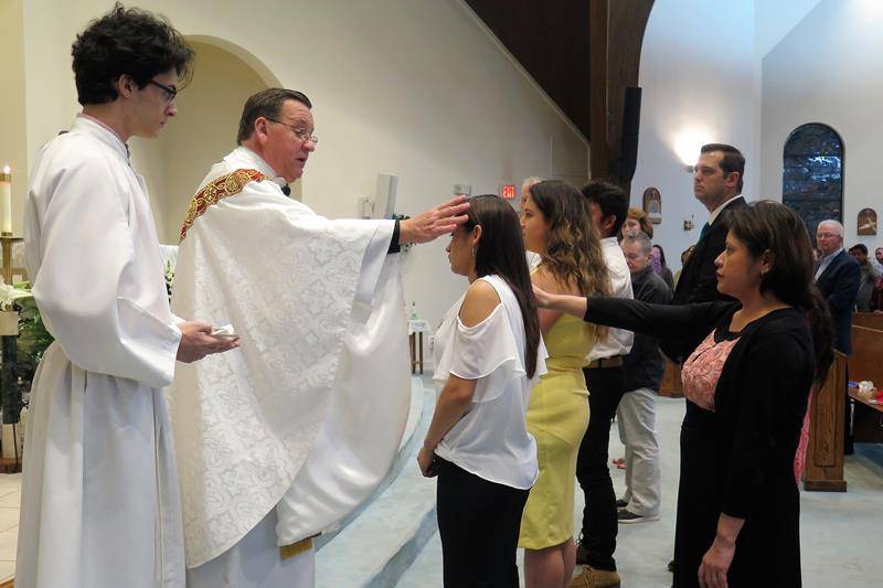 Father Thomas Kessler, pastor, administers the sacrament of confirmation at the Easter Vigil at St. Philip the Apostle Church in Statesville. (Photo by Connie Ries)