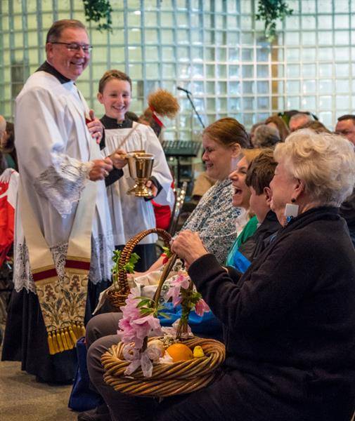 Easter baskets were blessed by Deacon James Witulski at St. Thomas Aquinas Church in Charlotte. The annual Polish tradition has grown very popular in recent years. (Photo by Doreen Sugierski)