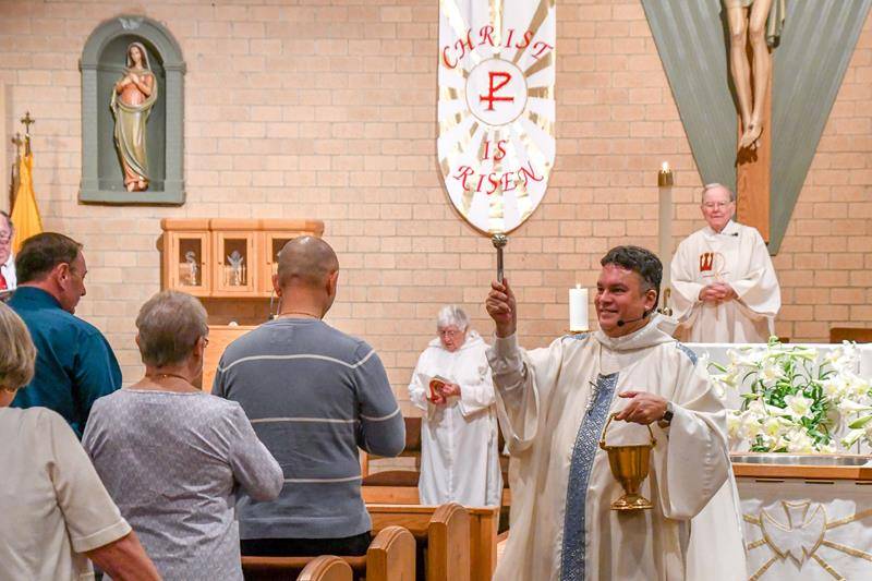 Father Alex Ayala blesses parishioners with holy water during the Easter Vigil at St. William Church in Murphy April 20. (Photo by Phil Roche)