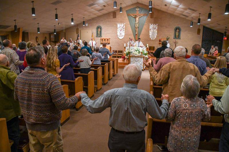 Parishioners pray the Our Father during the Easter Vigil at St. William Church in Murphy April 20. (Photo by Phil Roche)