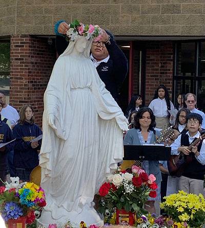 Our Lady of the Assumption School students gathered around the image of Our Blessed Mother, Mary, during the schools annual May Crowning. (Photo provided by Deacon David Reiser and Allana-Rae Ramkissoon)