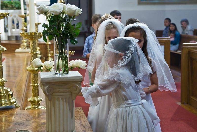 CHARLOTTE — First Communicants and children of St. Patrick Cathedral were invited to place flowers in a vase before the statue of Our Lady on Mother’s Day. Two of the First Communicants were chosen to crown her statue in the Marian grotto. 