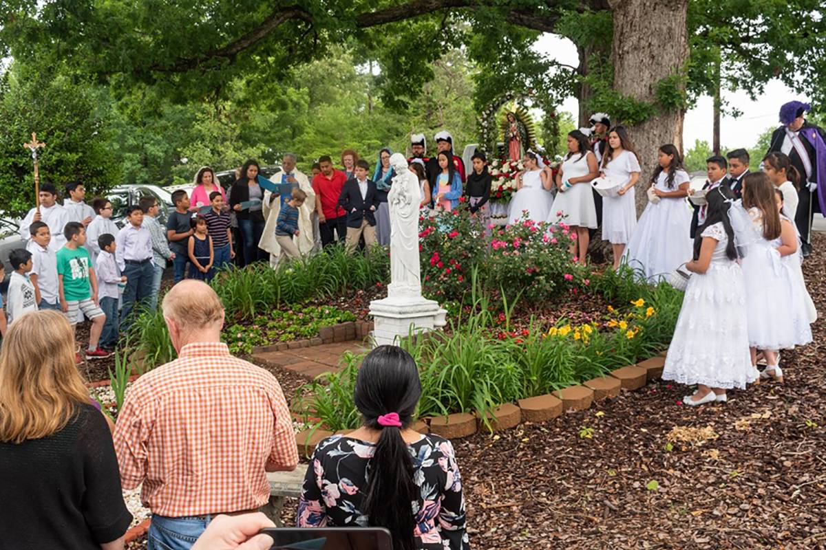 Members of Knights of Columbus Council 10891 carried an image of Mary on a platform decorated with flowers for the procession. The children completed the celebration by offering flowers to an image of Mary and placinph Church in Asheboro held its annual M