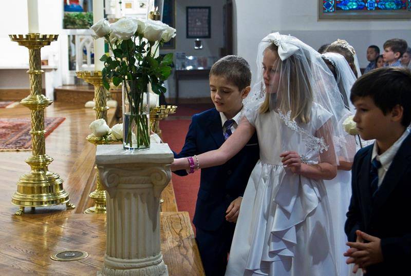 CHARLOTTE — First Communicants and children of St. Patrick Cathedral were invited to place flowers in a vase before the statue of Our Lady on Mother’s Day. Two of the First Communicants were chosen to crown her statue in the Marian grotto. 