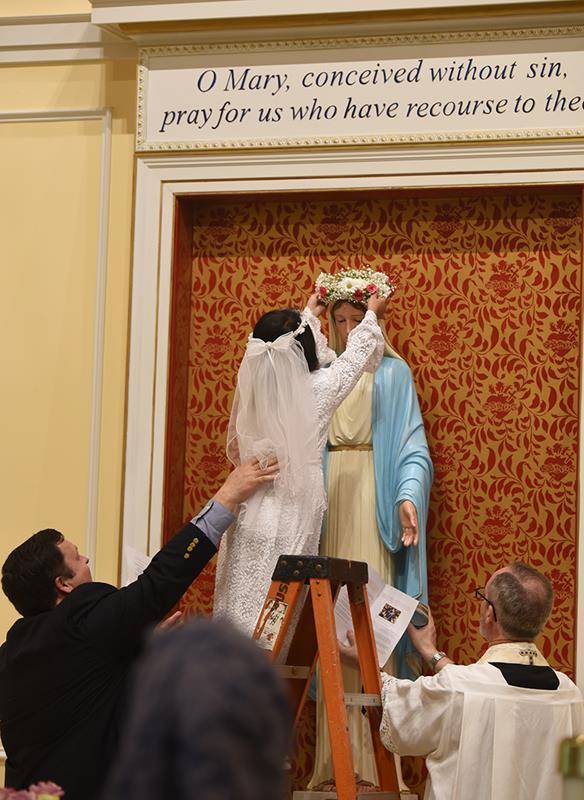 CHARLOTTE — Homeschooled students in St. Ann Parish crowned a statue of Mary inside the church after Mass May 19. (Photo provided by Markus Kuncoro)