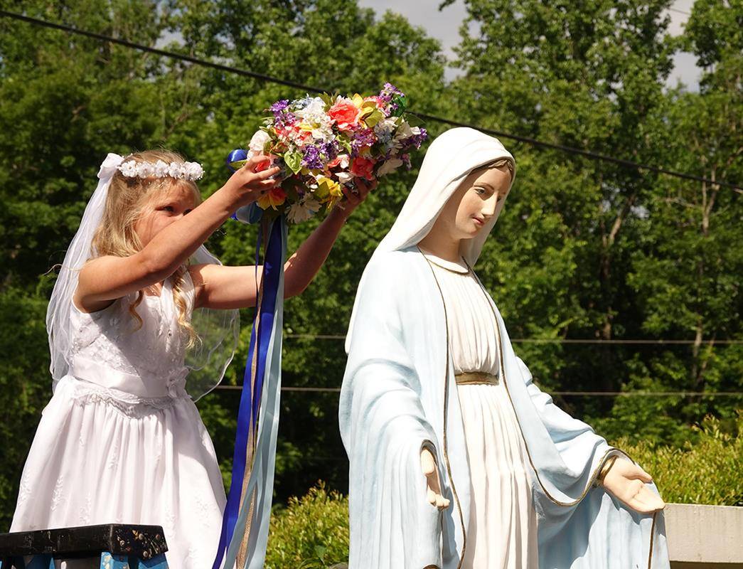 Second-graders Mary Walsh and David Balmaceda crowned the newly painted image of Mary in the school’s courtyard. (Photos provided by Amy Burger) 