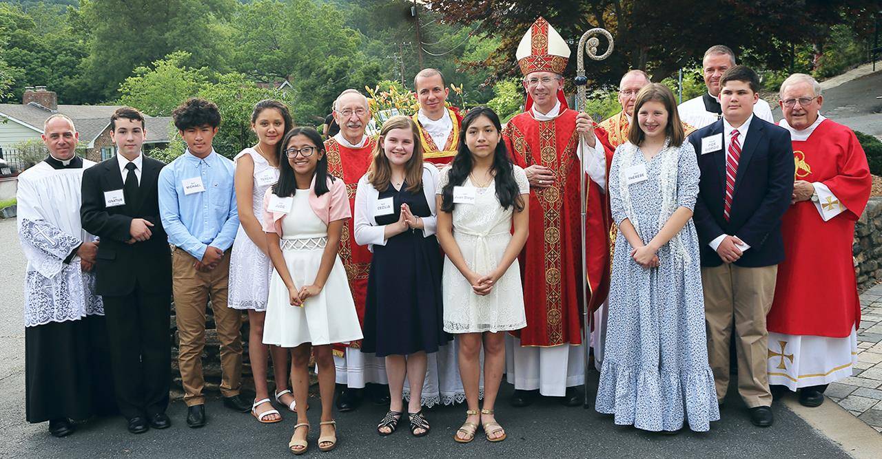 TRYON — Eight young people received the sacrament of confirmation from Bishop Peter Jugis June 27 at St. John the Baptist Church. Pictured is Ruth Ramirez-Camacho being confirmed by the bishop as Father Jason Christian looks on.(Giuliana Polinari Riley)
