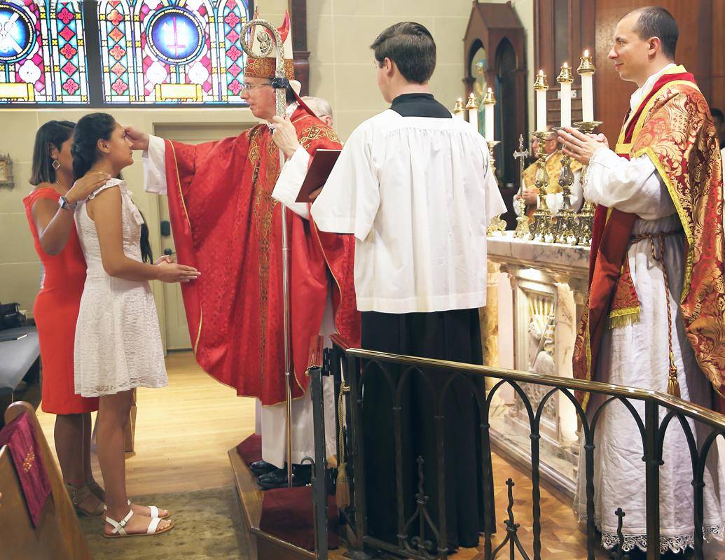 TRYON — Eight young people received the sacrament of confirmation from Bishop Peter Jugis June 27 at St. John the Baptist Church. Pictured is Ruth Ramirez-Camacho being confirmed by the bishop as Father Jason Christian looks on.(Giuliana Polinari Riley)