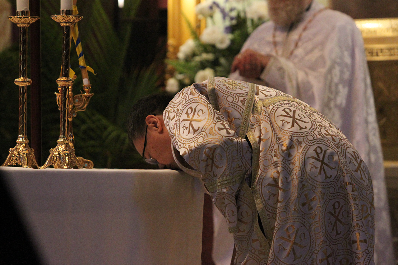 Basilius Magnus kisses the four corners of the altar during the deacon ordination rite.