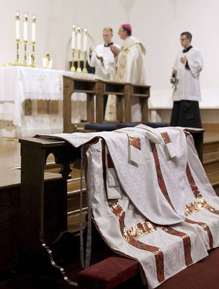 The men draped their vestments along the communion rail for the bishop to bless after the Holy Hour.