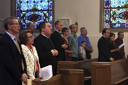 Each future priest stands with his family at the start of the Holy Hour at St. Patrick Cathedral in Charlotte.