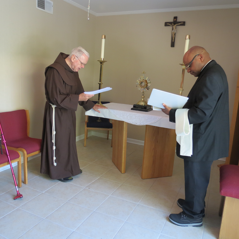 Father Marcel Amadi, current campus minister, and former campus minister Franciscan Father David Hyman. (Georgianna Penn, correspondent)