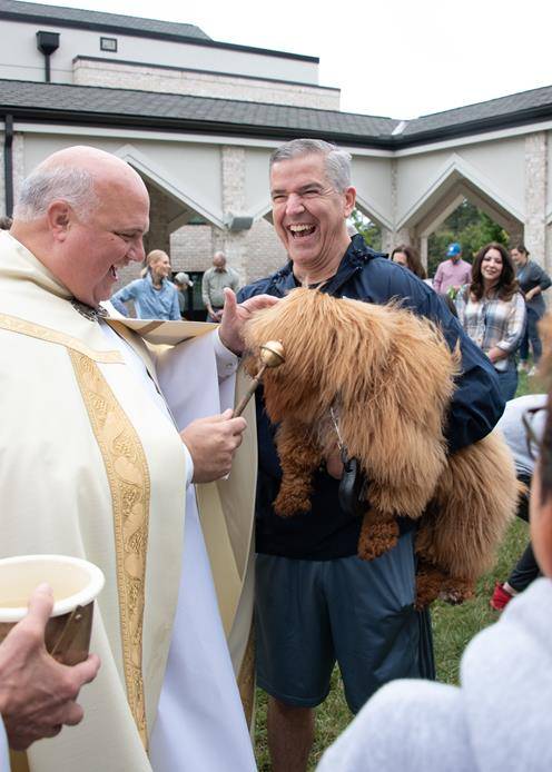 GREENSBORO — Monsignor Marccacio with David Long and their miniature Goldendoodle “Teddy” (Photos by MaryAnn Luedtke)
