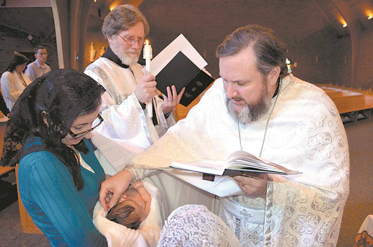 Pictured, an infant is anointed with sacred chrism by Father Mark Shuey. During “chrismation,” a person is anointed on the forehead, eyes, nose, lips, breast, hands and feet to sanctify the mind, body, soul and all the senses to serve God.