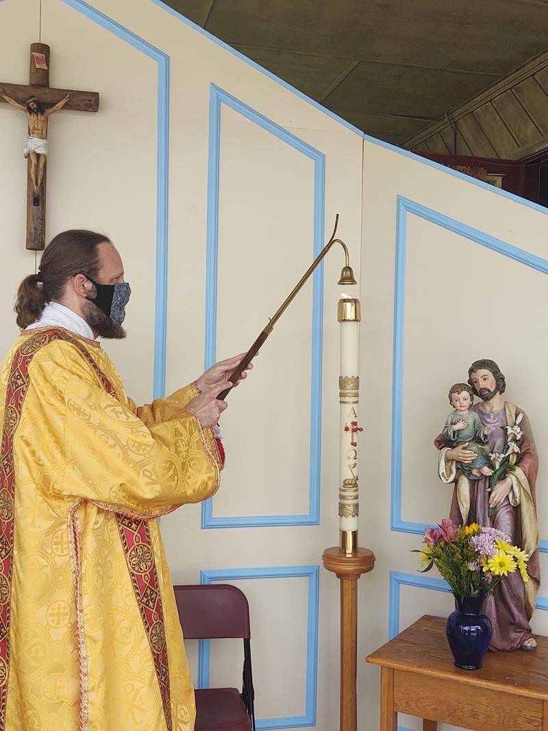 Deacon Matthew Newsome lights the Easter candle before an outdoor Mass at St. Mary, Mother of God Church in Sylva May 17. (Della Sue Bryson | Catholic News Herald)