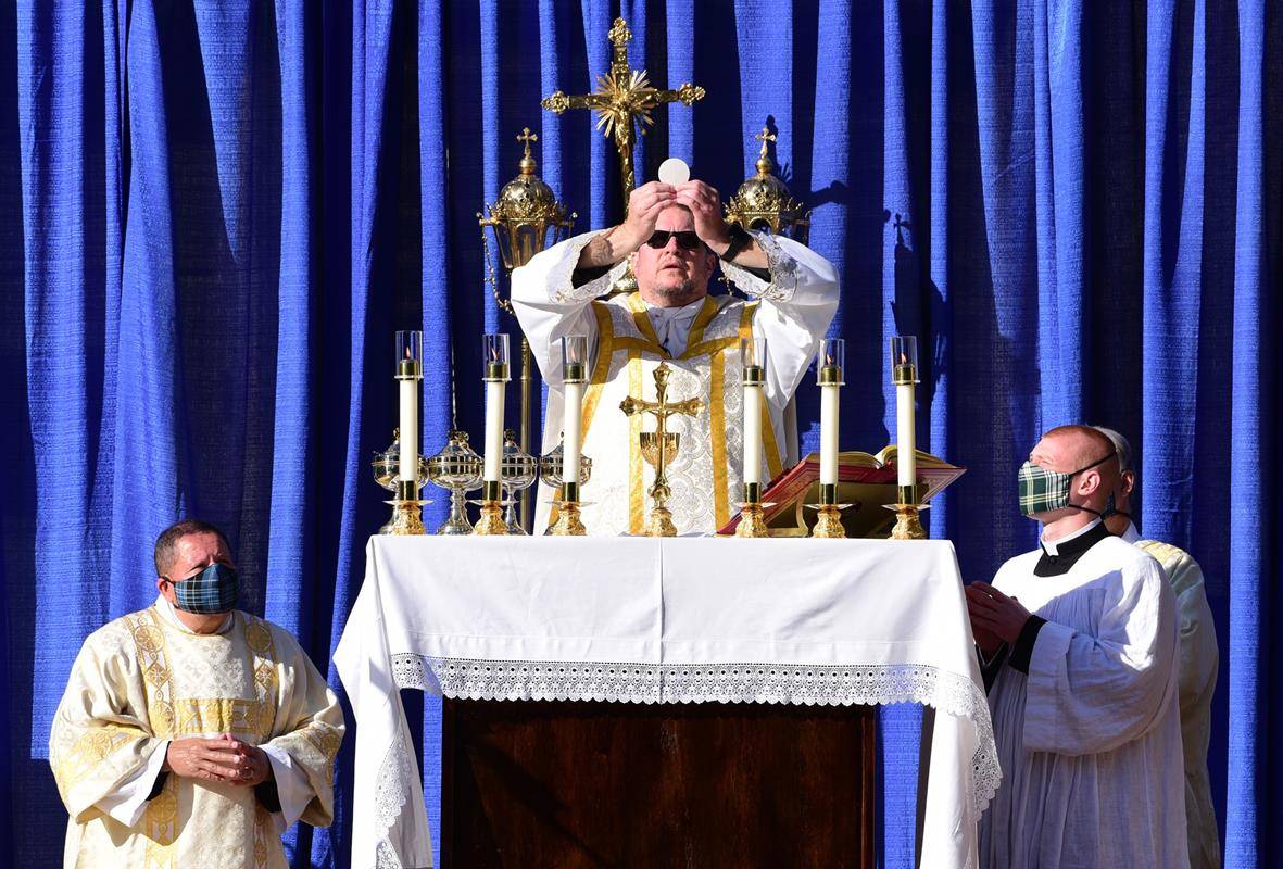 Father Christopher Roux, rector, elevates the Eucharist at an outdoor Mass at St. Patrick Cathedral May 10, the first public liturgy for the parish since the pandemic began in mid-March. (Photo provided by James Sarkis) 