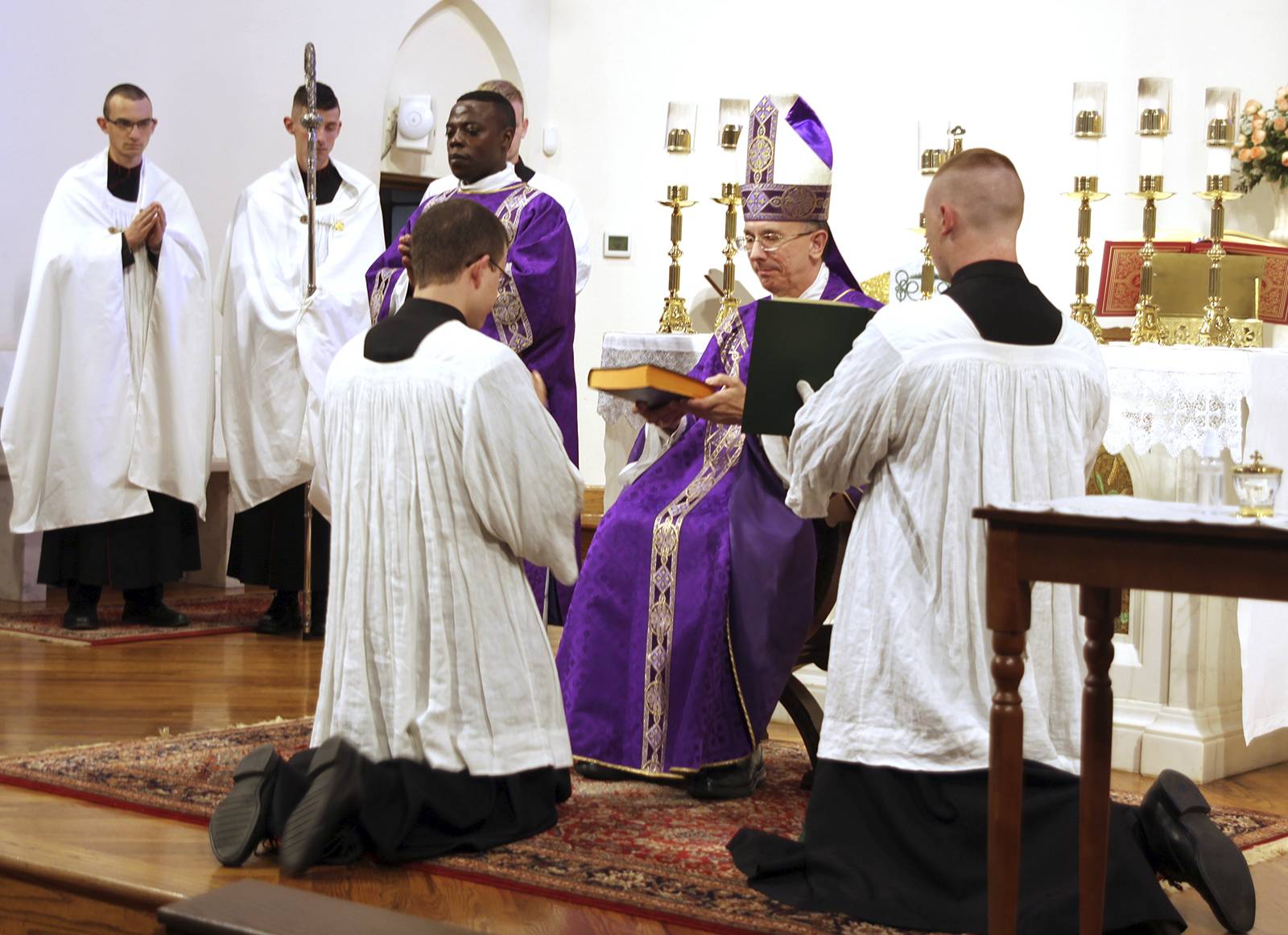 Christopher Brock receives the Bible from Bishop Jugis.