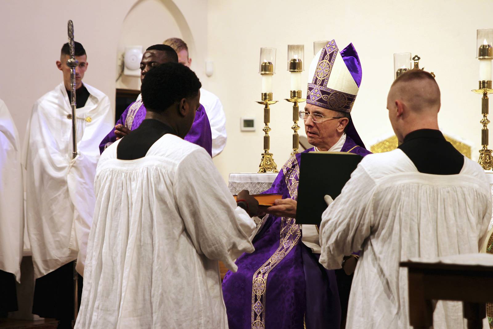 Chinonso Nnebe-Agumadu receives the Bible from Bishop Jugis.
