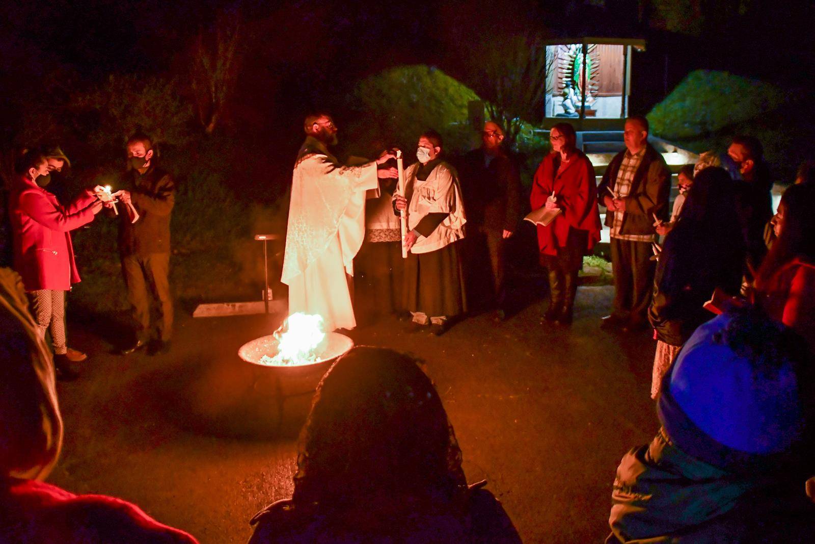 Father George David Byers, pastor, lights the Paschal candle during the Easter Vigil at Holy Redeemer Church in Andrews, as parishioners gather joyfully around him. (Phil Roche | Catholic News Herald)