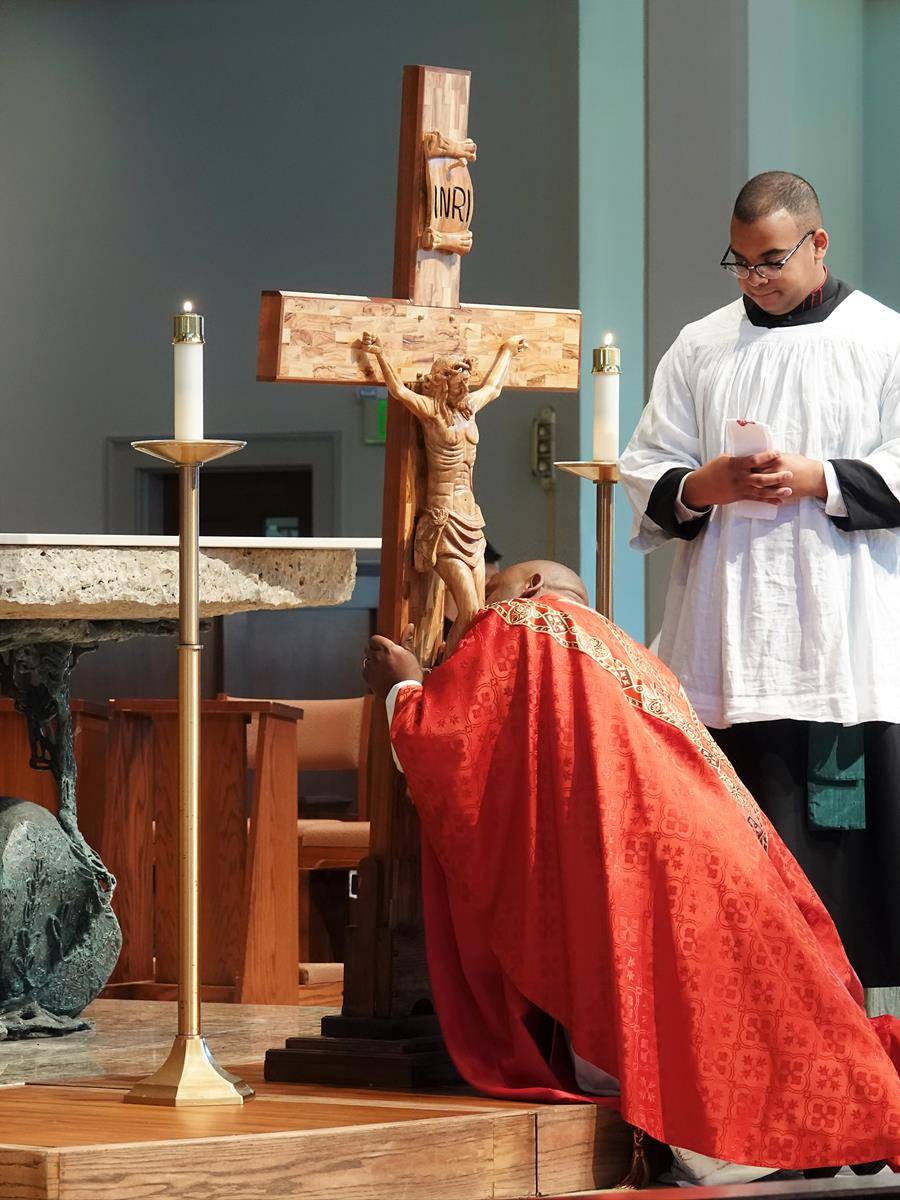 Father Melchesideck Yumo, parochial vicar, was among those who venerated the cross on Good Friday at St. Mark Church in Huntersville. (Photo provided by Amy Burger)