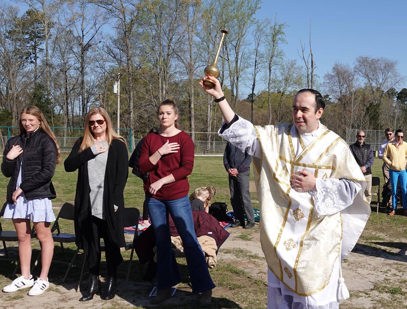 Father Alfonso Gámez, parochial vicar, blesses congregants with holy water during an outdoor Easter Sunday Mass, one of six Masses St. Mark offered that morning to accommodate more worshipers. (Photos provided by Amy Burger)